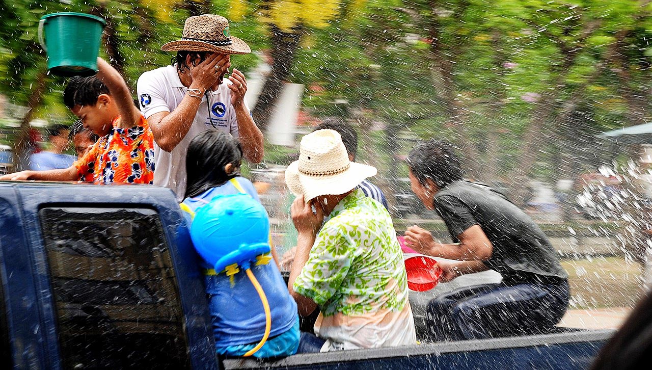 Persone divertite in una tradizionale battaglia d'acqua durante il Songkran.